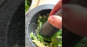 Making pesto in a pestle and mortar